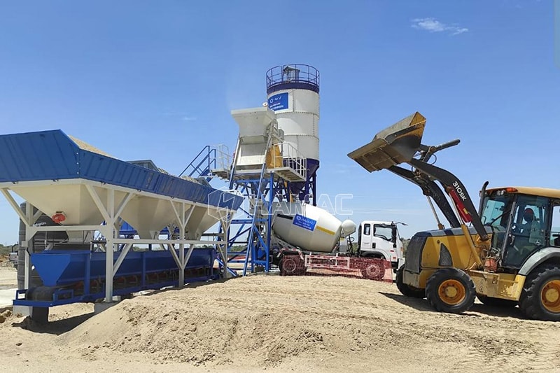 Stationary concrete batching plant fed by backhoe loadert