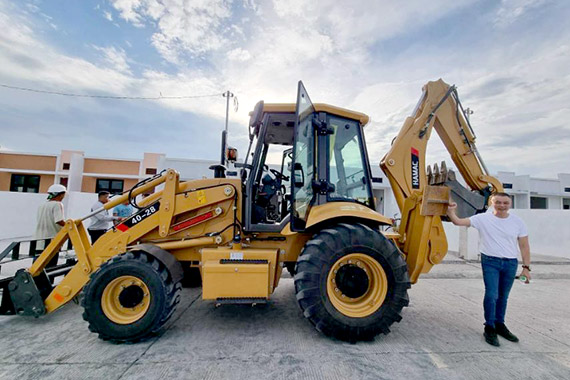 HAMAC backhoe loader working on a Philippine housing jobsite