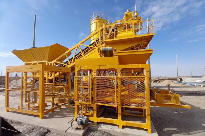 Stationary concrete batching plant fed by backhoe loader